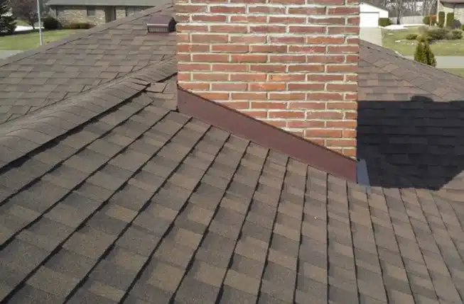 close up of brown roof shingles and flashing repair